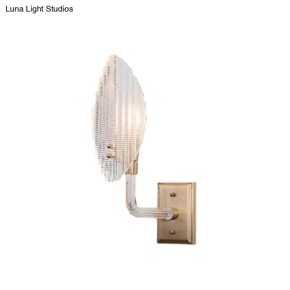 Contemporary brass leaf wall light fixture with a ribbed glass shade and curved arm for living room wall light