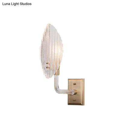 Contemporary brass leaf wall light fixture with a ribbed glass shade and curved arm for living room wall light
