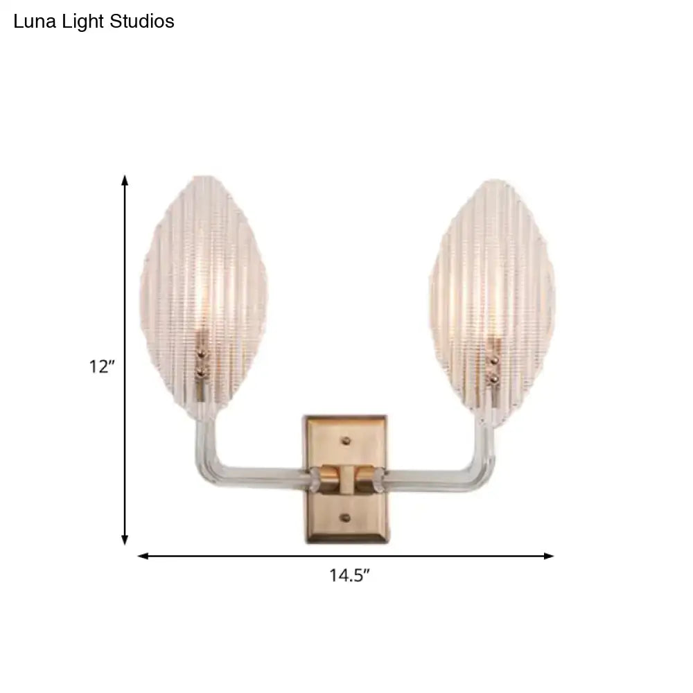 Contemporary brass leaf wall light fixture with clear glass arms and frosted ribbed glass shades for living room