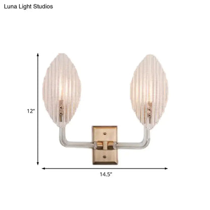 Contemporary brass leaf wall light fixture with clear glass arms and frosted ribbed glass shades for living room