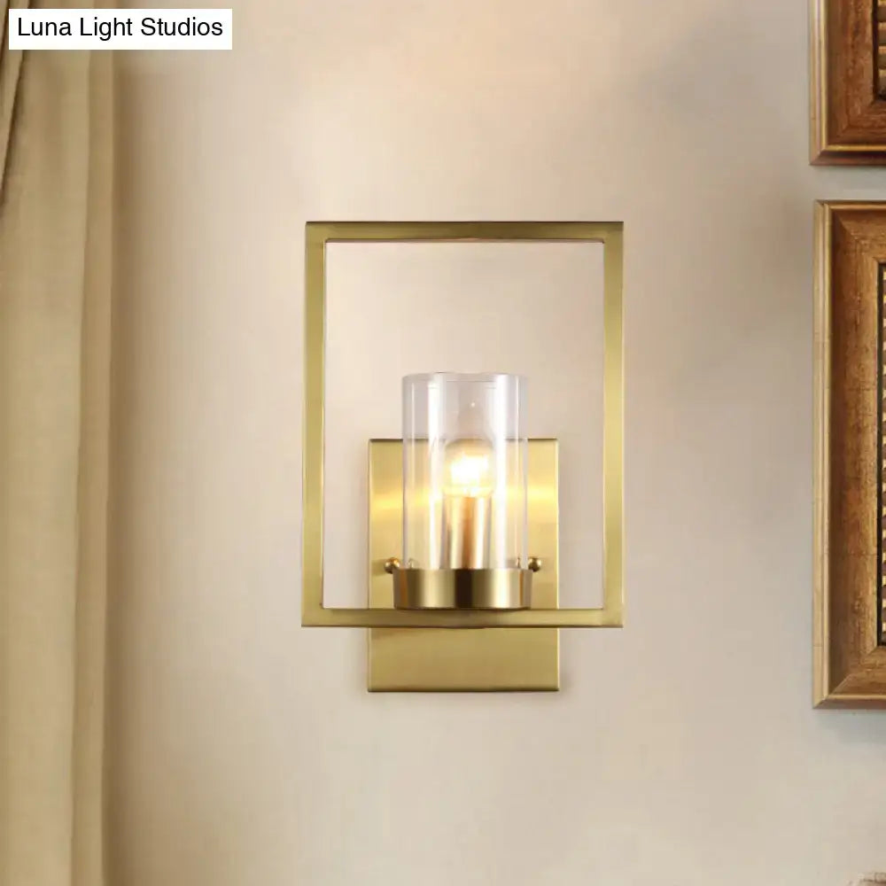 Contemporary brass wall light with clear glass cylinder shade brass-framed light fixture for bedroom use
