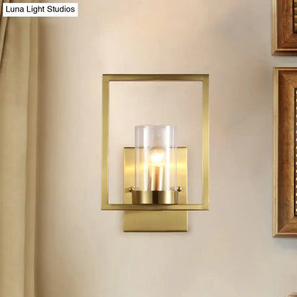 Contemporary brass wall light with clear glass cylinder shade brass-framed light fixture for bedroom use