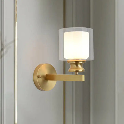Contemporary brass wall mounted light fixture with gold-toned finish and frosted glass shade for living room use