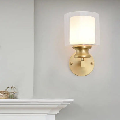 Contemporary brass wall mounted light fixture with frosted glass shade in gold tone for living room use