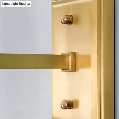 Gold-finished brass door handle with sleek modern design and two matching knurled knobs for contemporary wall sconce