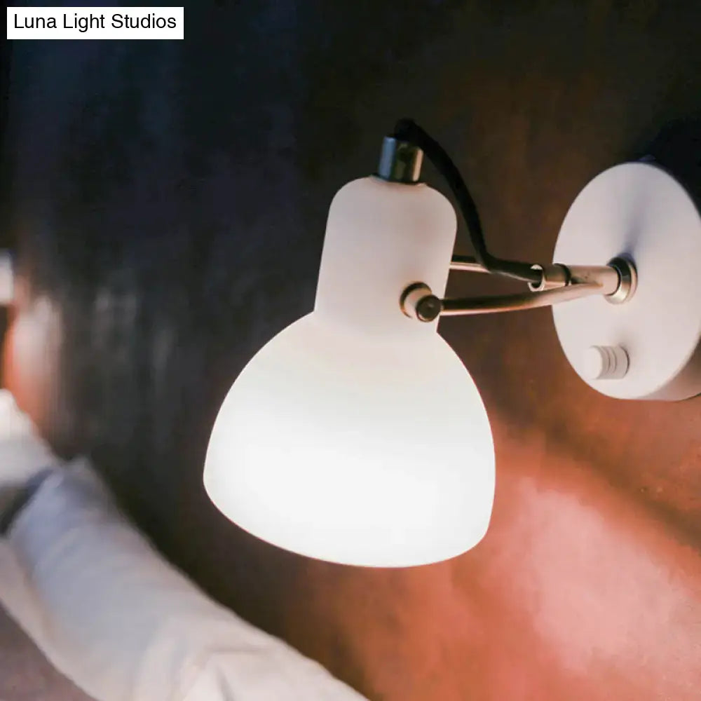 Contemporary wall lamp with white glass domed shade and brass adjustable arm for bedroom lighting