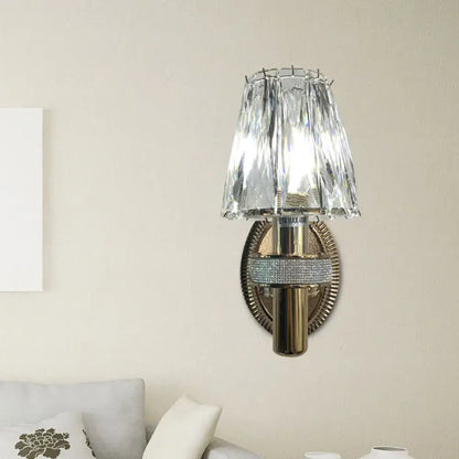 Contemporary bronze wall sconce light with crystal-encrusted brass and tiered faceted glass shade for bedroom use