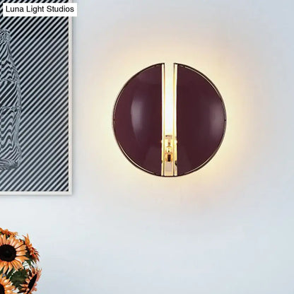 Contemporary wall lamp with a modern circular design, glossy dark purple finish, and central gold-toned accent strip