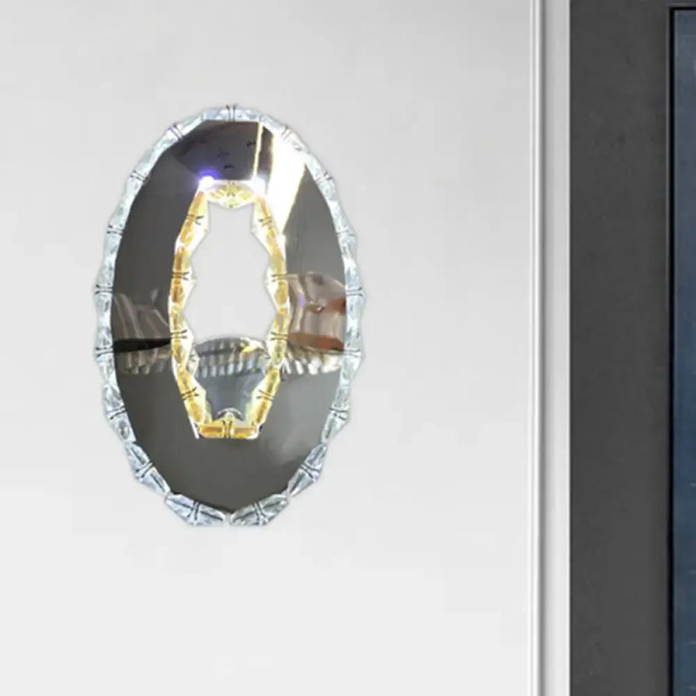 Contemporary silver-framed oval light fixture with decorative beaded edge and warm white crystal interior design mirror