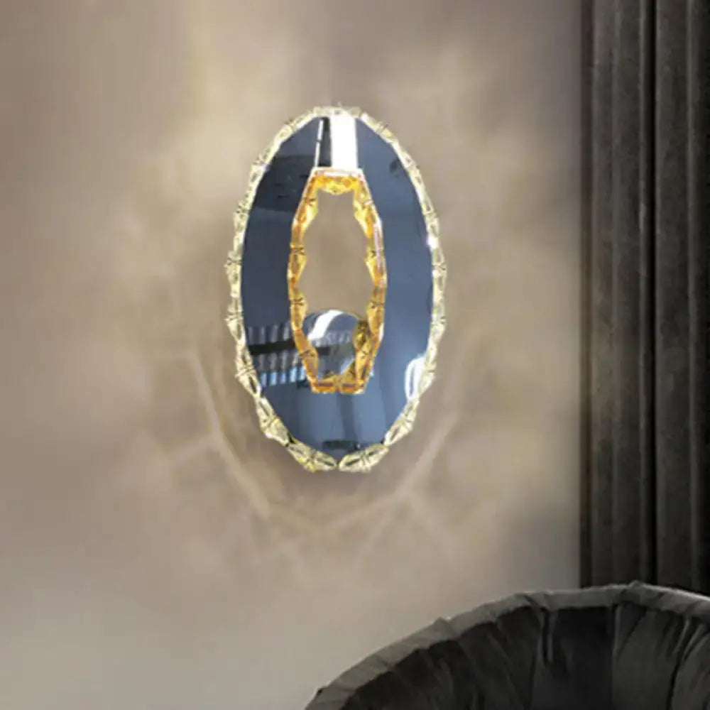 Contemporary oval wall mirror with gold-toned faceted crystal frame and ornate design for warm white bedroom light fixture