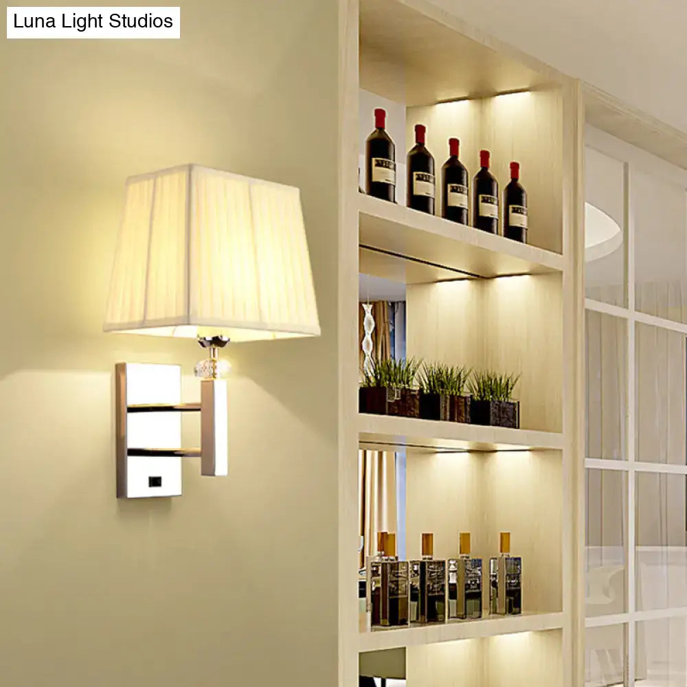 Contemporary cream fabric lampshade on chrome bedroom wall sconce light fixture with metallic spot light accents