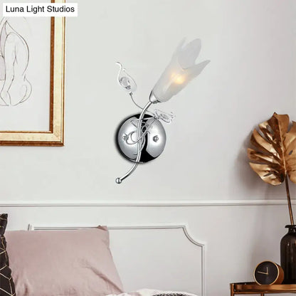 Contemporary chrome e12 wall sconce with sculpted floral design and frosted opal glass petals for bedroom use