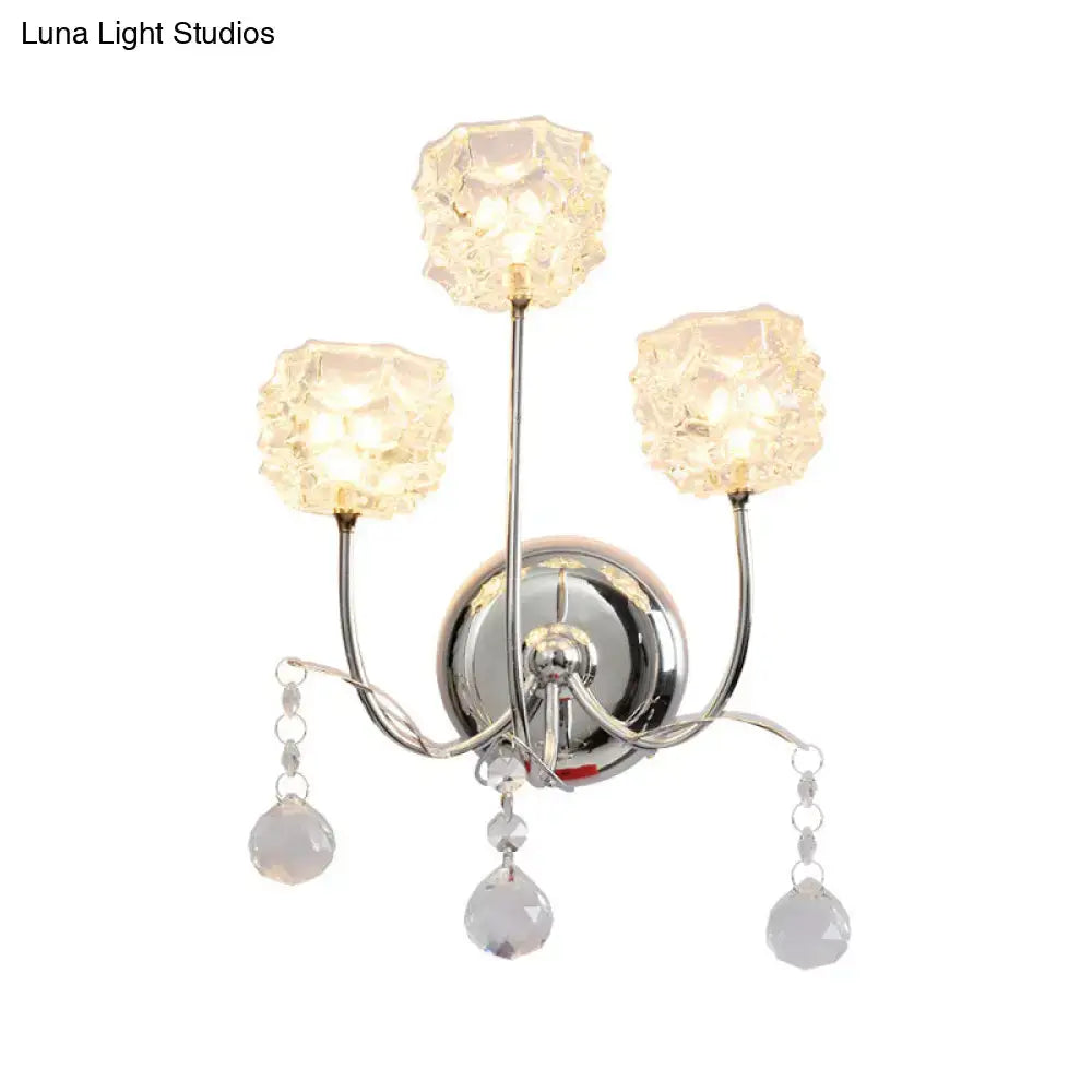 Contemporary chrome wall sconce with three faceted crystal shades and dangling teardrop crystals featuring fixture height