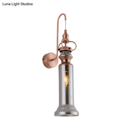 Contemporary copper wall sconce with smoke gray amber tall cylindrical glass shade and exposed filament bulb for bedroom light