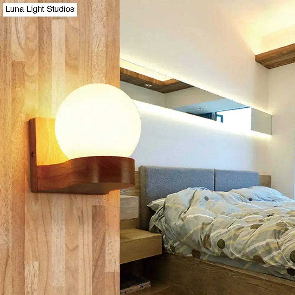 Contemporary cream glass sconce light fixture with warm wood base for living room wall lighting