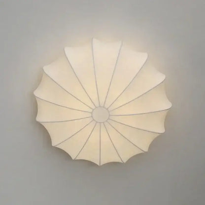 Cream-colored petal-shaped led ceiling light with soft diffused glow and subtle radial lines for dining room