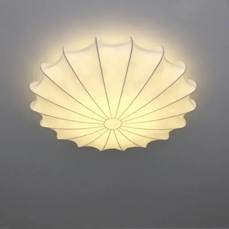 Contemporary cream petal led ceiling light with scalloped fabric design and black ribs for dining room use