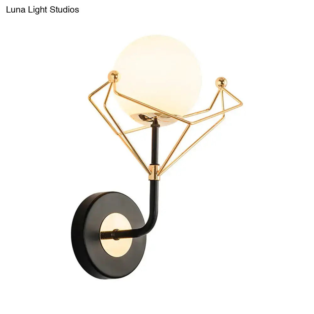 Contemporary gold and black glass orb wall sconce with cream glass orb and black circular base for bedroom lighting