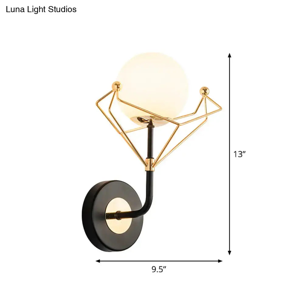 Contemporary gold and black glass orb wall sconce with a cream glass orb for bedroom lighting