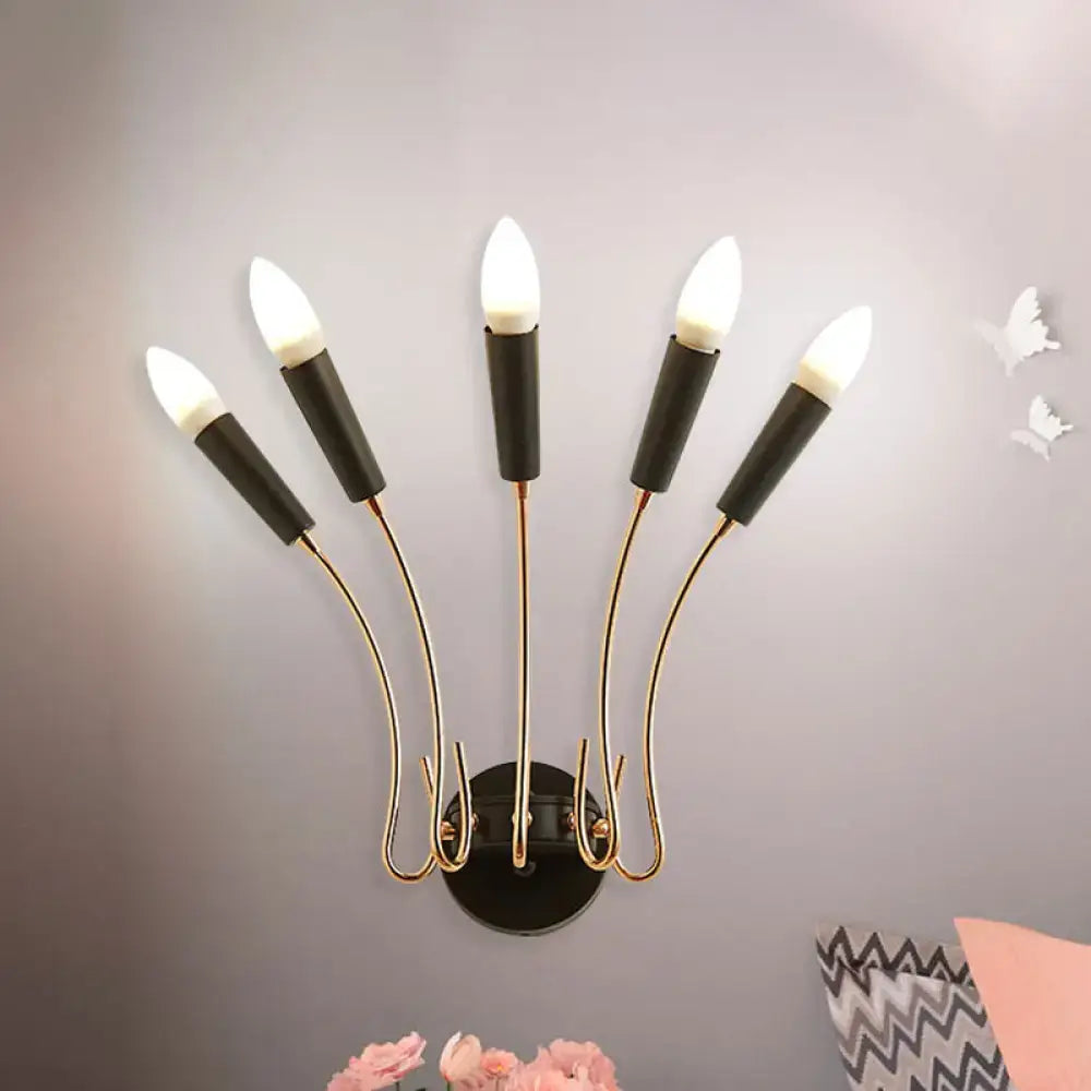 Contemporary metal sconce with five gold-toned arms and black bases featuring illuminated white bulbs for living room use