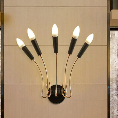 Contemporary metal sconce with five curved gold-toned arms and black bases holding candle-style bulbs for living room