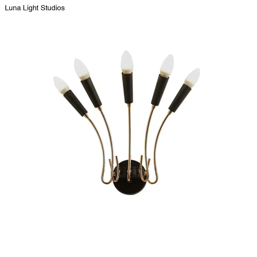 Contemporary metal sconce with black and brass five-light curved arms and frosted glass bulbs for living room use