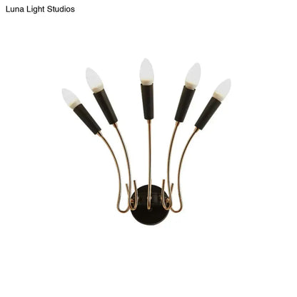 Contemporary metal sconce with black and brass five-light curved arms and frosted glass bulbs for living room use