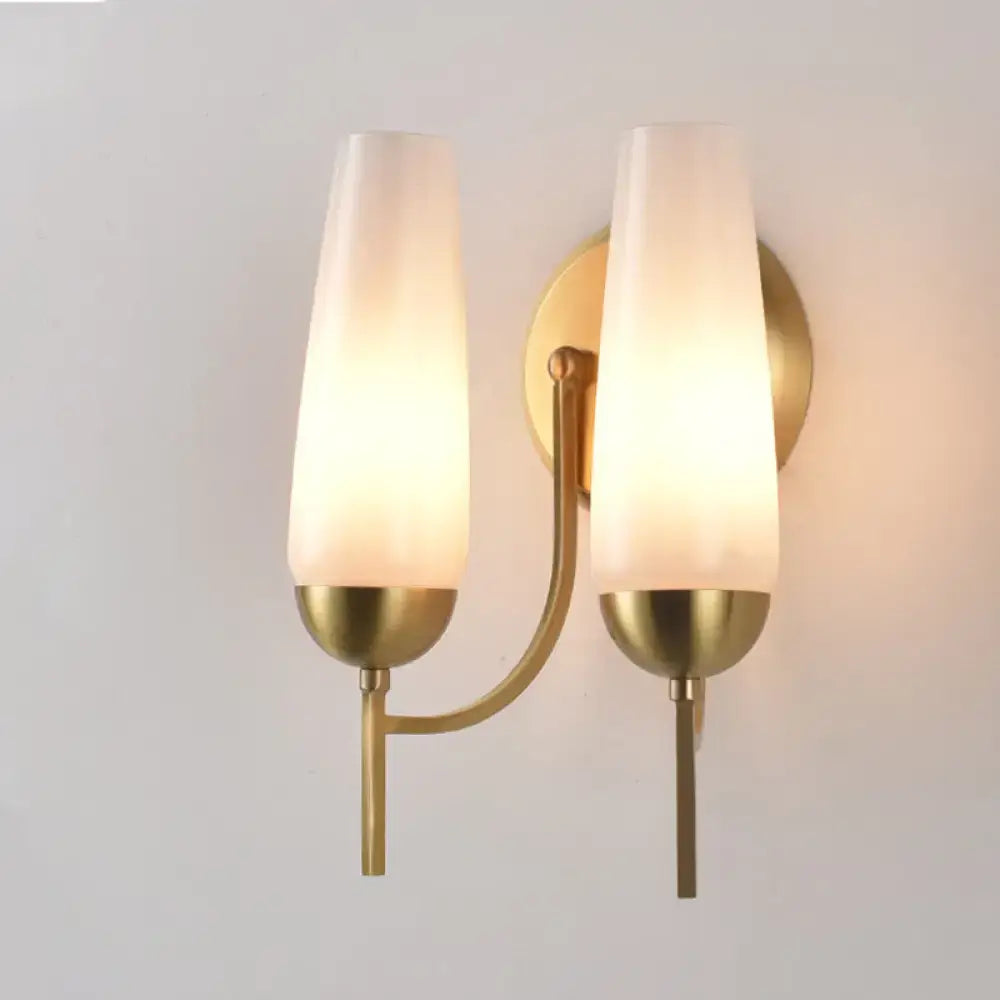 Contemporary gold and opal conical wall sconce with brass finish and two frosted glass shades for bedroom lighting