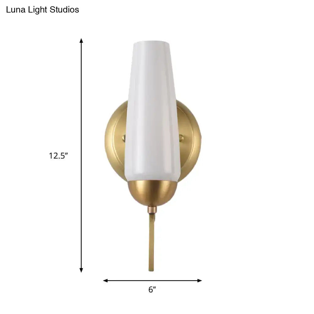Contemporary gold and opal conical wall sconce with sleek white frosted glass and brushed brass base for bedroom lighting