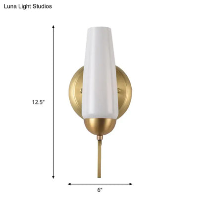 Contemporary gold and opal conical wall sconce with sleek white frosted glass and brushed brass base for bedroom lighting