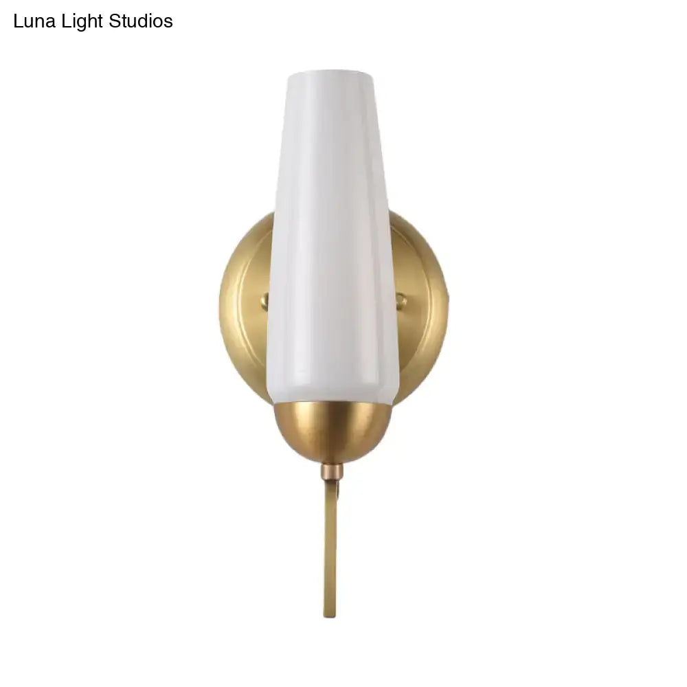 Contemporary gold and opal conical wall sconce with a white frosted glass shade and polished brass slender stem for bedroom lighting
