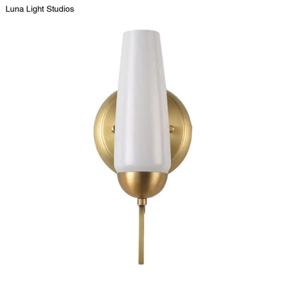 Contemporary gold and opal conical wall sconce with a white frosted glass shade and polished brass slender stem for bedroom lighting