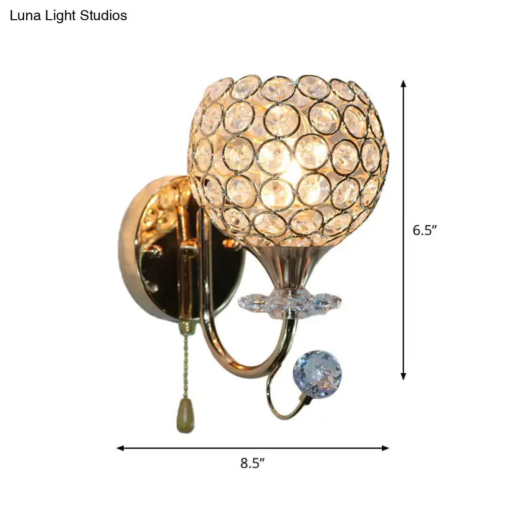 Contemporary gold wall sconce with beveled glass globe and dangling crystals for living room lighting