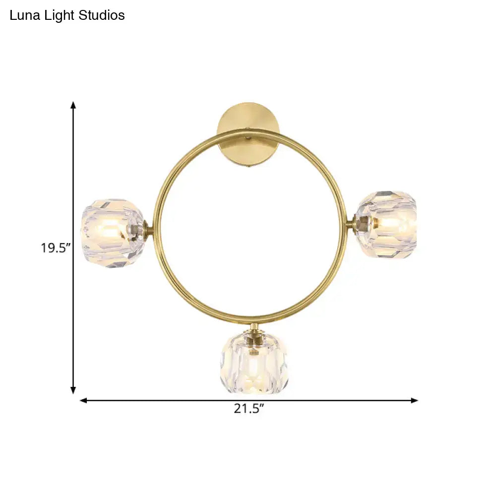 Contemporary gold brass wall light fixture featuring a circular design with three faceted crystal bulbs for bedrooms