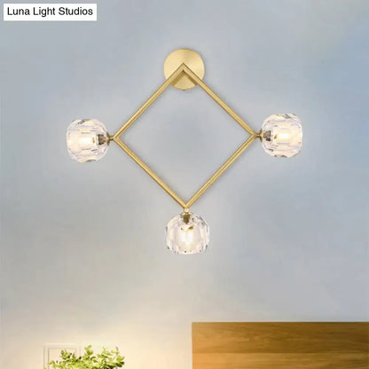 Contemporary gold brass wall light fixture with diamond shape and three faceted crystal globe lights for bedrooms