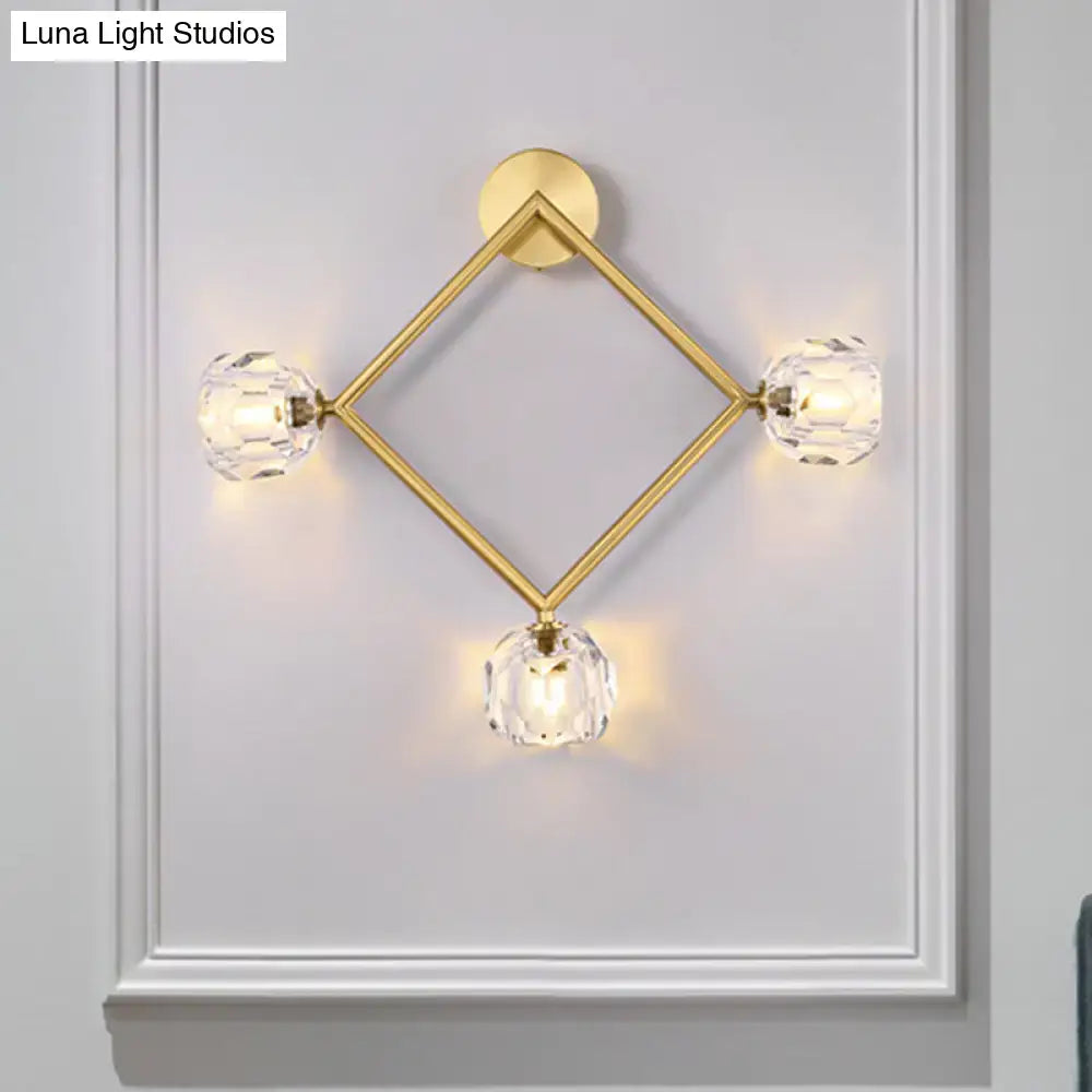 Contemporary gold brass wall light fixture with diamond-shaped design and three faceted crystal globe lights for bedroom