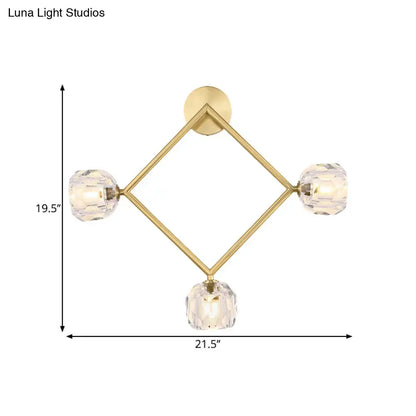 Contemporary gold brass wall light fixture with diamond-shaped design and three faceted crystal globe lights for bedroom