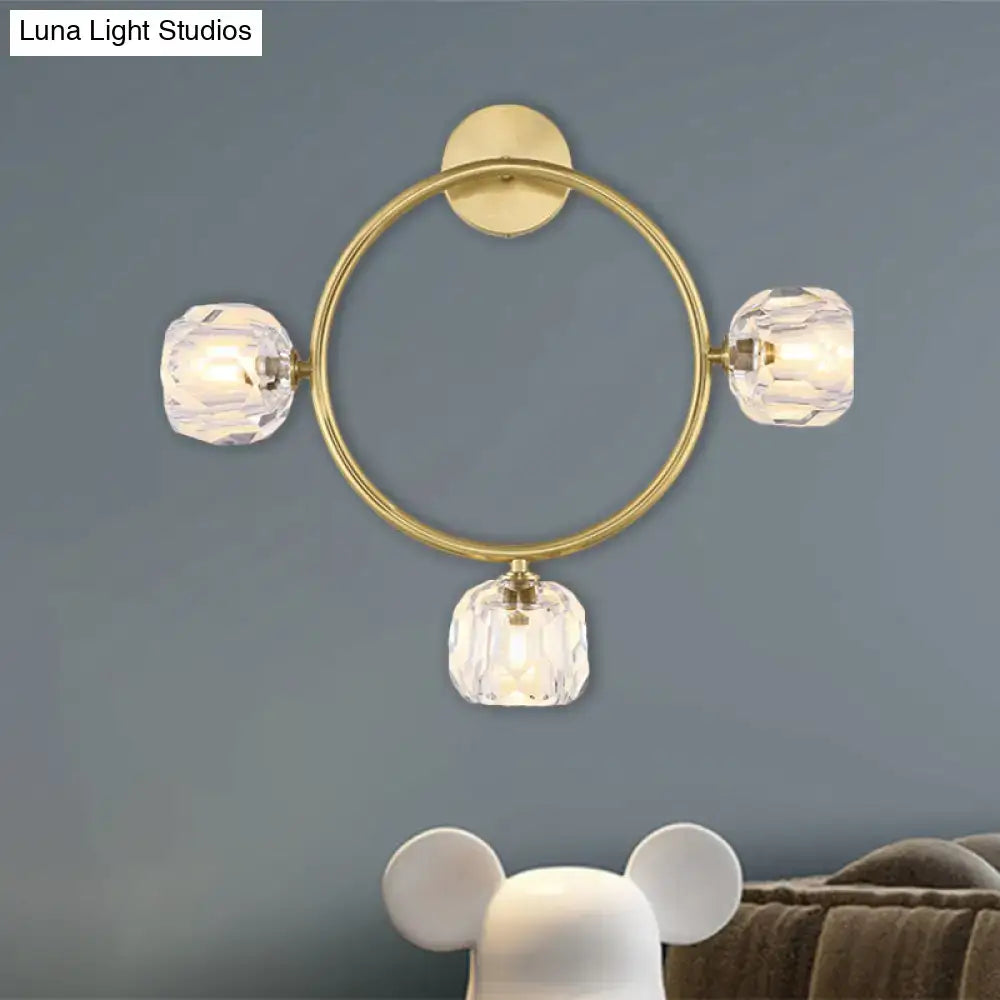 Contemporary gold brass wall light fixture with three faceted crystal shades designed as a circular wall light sconce