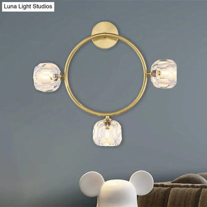 Contemporary gold brass wall light fixture with three faceted crystal shades designed as a circular wall light sconce