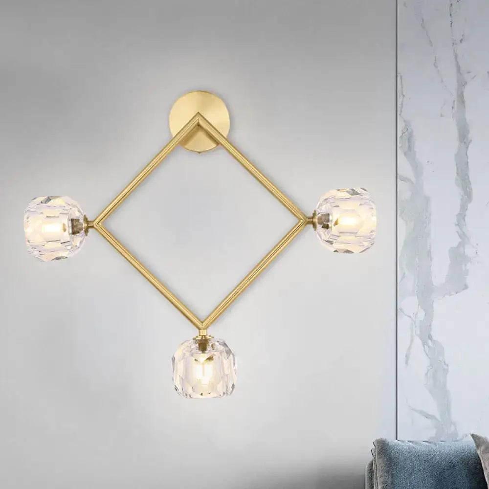 Contemporary gold brass wall light fixture with geometric design and three faceted crystal shades for bedroom use