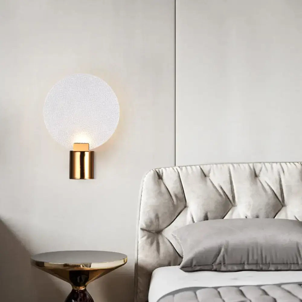 Contemporary gold wall lamp with frosted bubble glass shade designed as a bedroom sconce