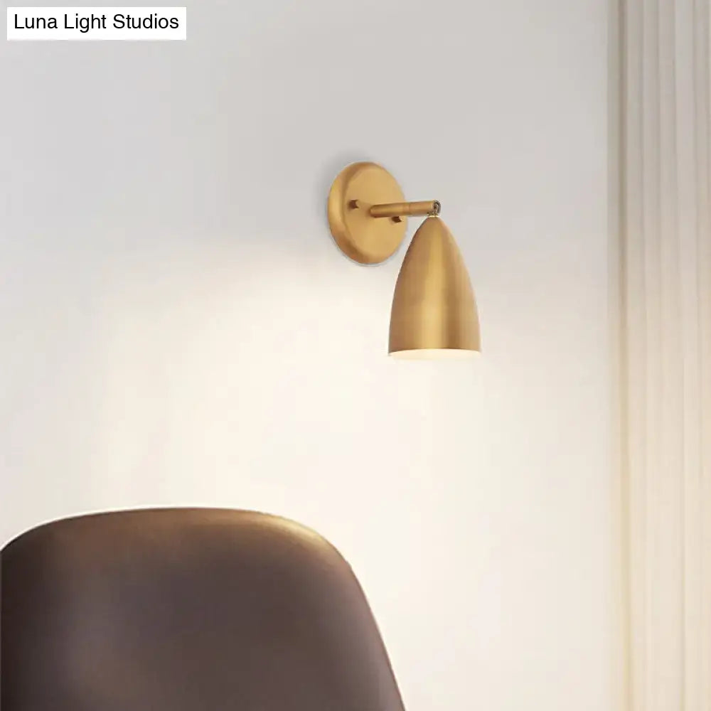 Contemporary brass-finished wall mount lamp with a sleek gold conical shade for bedroom spotlight lighting