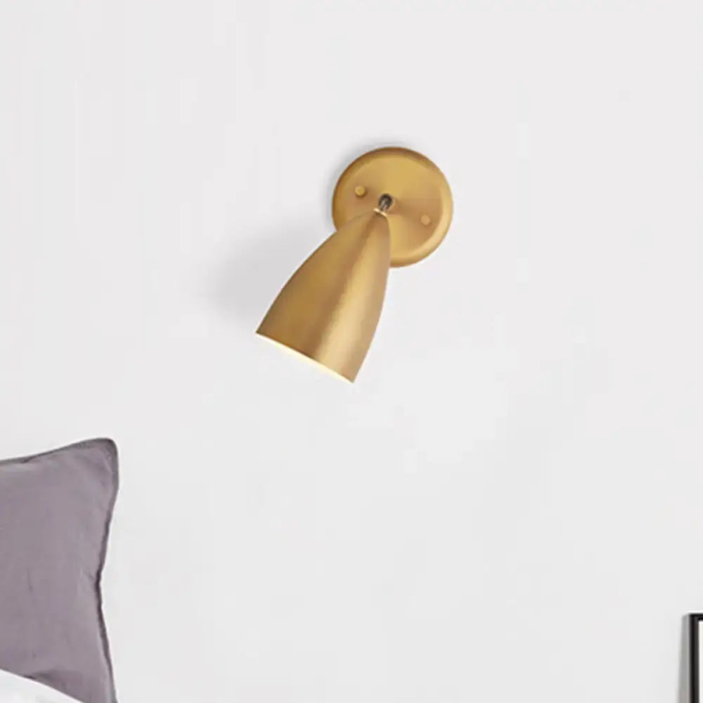 Contemporary gold wall mount lamp with a sleek conical shade and circular base for bedroom spotlight use