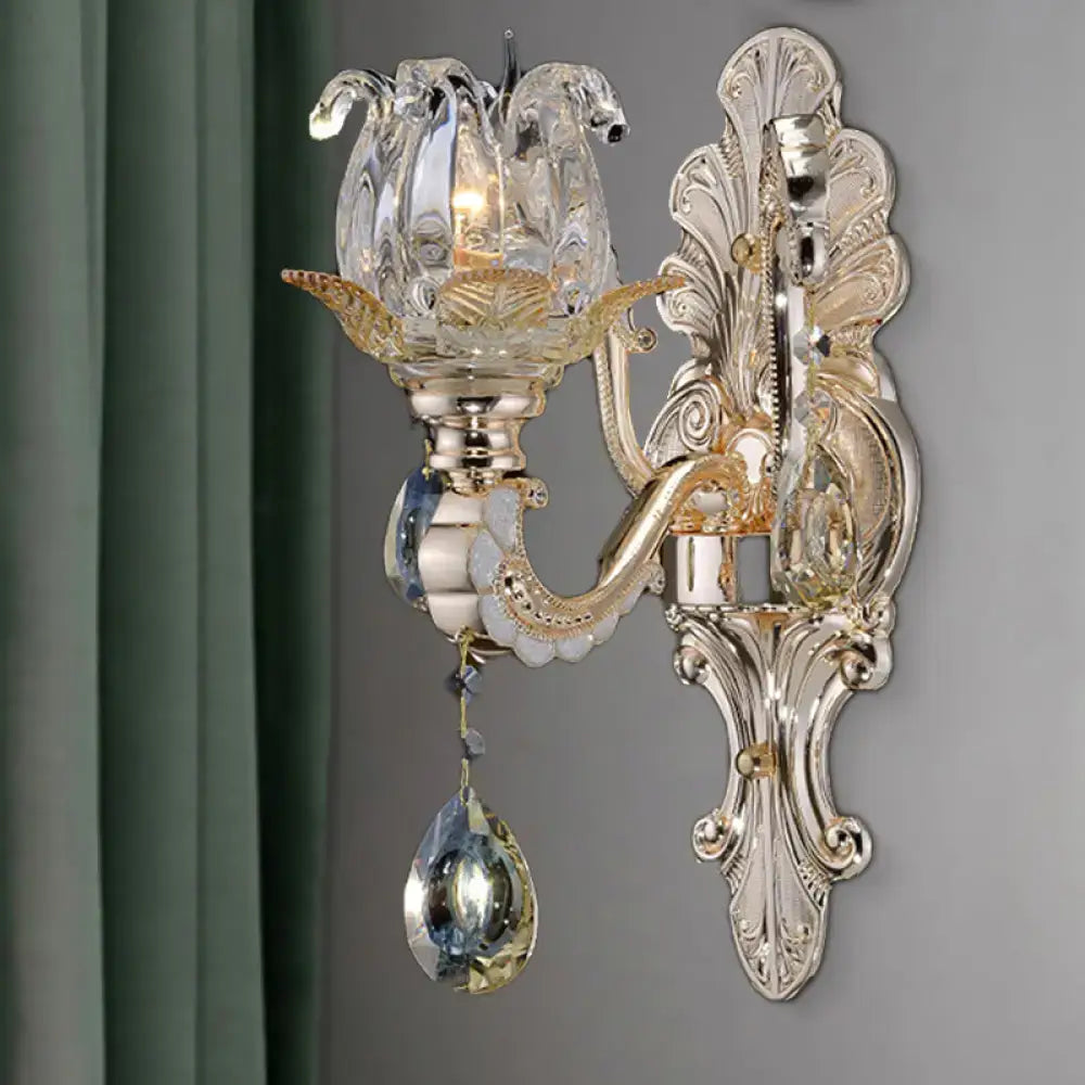 Elegant gold-toned wall lamp with crystal drop lotus design featuring dangling teardrop crystals for bedroom light fixture