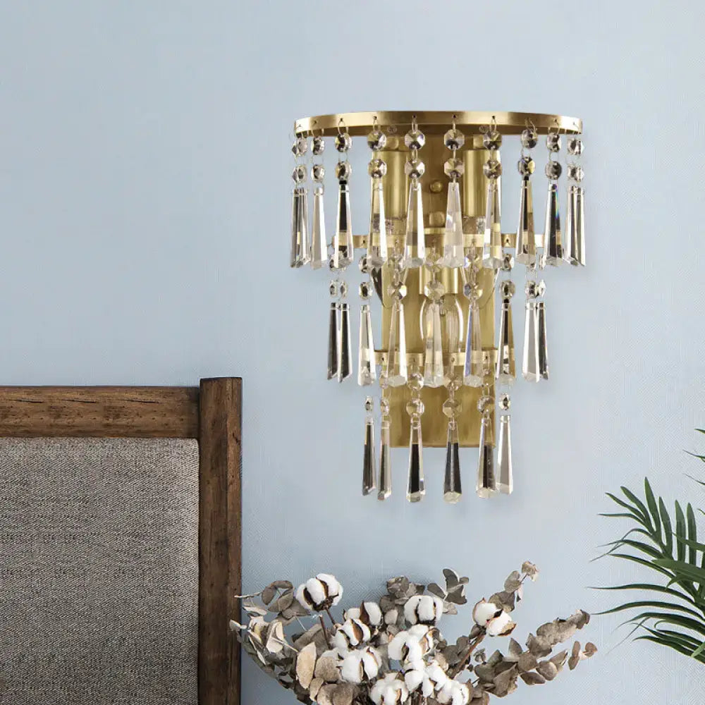 Contemporary gold crystal flute tiered wall sconce lighting with cascading clear crystal droplets for bedroom use