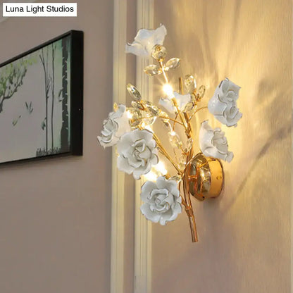 Elegant white ceramic rose wall lamp with gold-toned metal branches and crystal accents for contemporary wall light