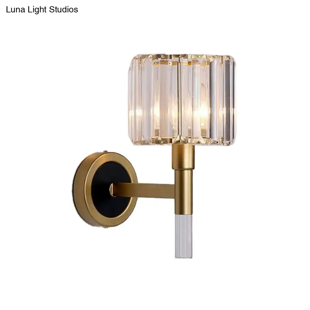 Contemporary gold wall mount lamp with cylindrical crystal shade and clear glass stem for living room use