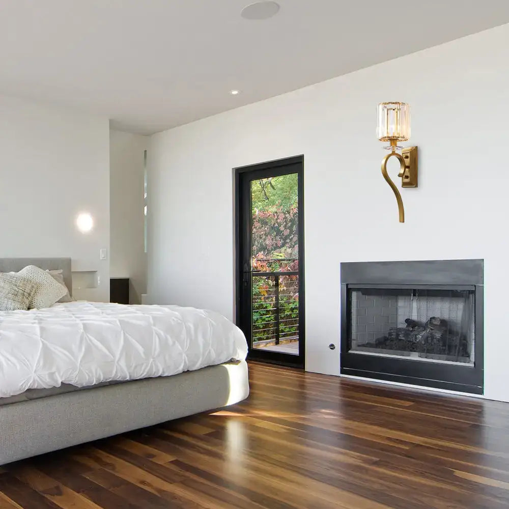 Contemporary gold cylinder wall light with crystal accents featuring a gold-toned curved wall sconce and clear glass shade