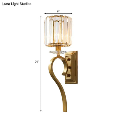 Contemporary gold cylinder wall light with faceted crystal shade and elegant curved arm for bedroom lighting