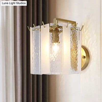 Contemporary gold drum wall sconce light with textured white glass panels and metal accents for bedroom use